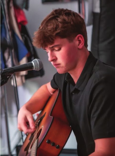 Nick Gallup playing guitar on a runway