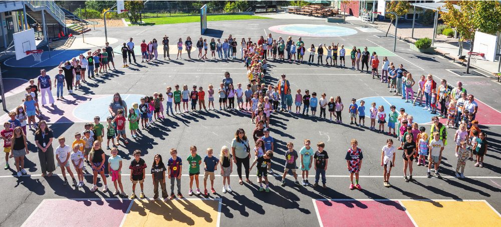 Students and staff forming a human peace sign on the field
