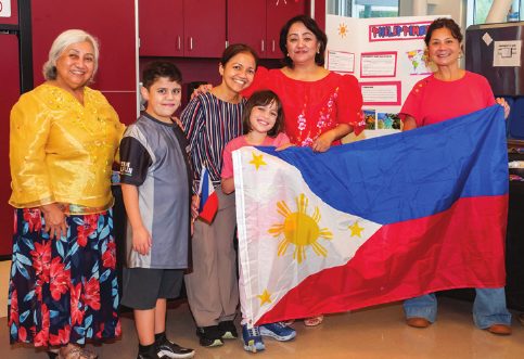 Students and families with flags at Many Cultures, One Community